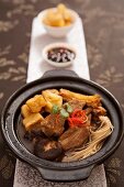 Schweinerippen mit Pilzen, Tofuwürfeln und Nudeln in Brühe (China)