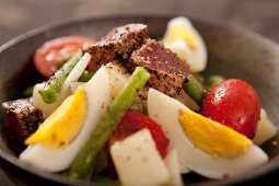 Rindfleischsalat mit gekochtem Ei, Tomaten und Bohnen