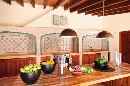 Obstschalen auf Holztisch in mediterranem Esszimmer mit gefliesten Wandnischen