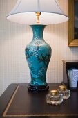 Tischlampe mit chinesisch bemaltem Vasenfuss auf Schreibtisch im Antikstil mit goldgeprägter Ledereinlage