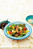 A salad of prawns with citrus fruits, and a bowl of harissa paste