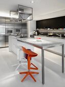 Designerküche mit farbigen Bistrohockern vor hohem Tisch und Marmorplatte