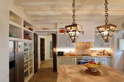 Mediterrane Küche mit Hängelampen im Retrostil über Esstisch