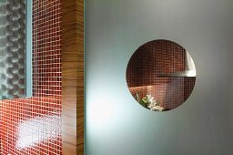 Küchenausschnitt - Blick durch Bullauge in satinierter Glastür auf rote Mosaikfliesen