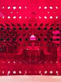 Blick durch Weinregalwand aus rotem Kunststoff