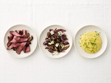 Rindersteak, geröstete Zwiebeln & Polenta auf drei Tellern