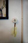 Vintage Lichtschalter und Schlitz mit Kartoffelbrei-Putz neben Aufputz-Kabeln