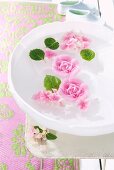 Rose-shaped, scented floating candles in bowl of water