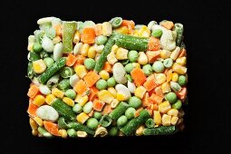 Block of Frozen Mixed Vegetables on a Black Background