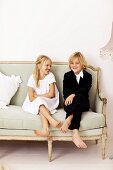 Mädchen und Junge auf einem nostalgischen Sofa