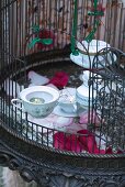 Tealight holders made from old teacups in birdcage