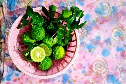 Kaffir limes in a pink plastic basket