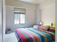 Bed linens with a striped pattern on a double bed in a minimalist bedroom