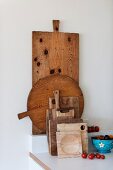 Collection of rustic chopping boards next to tomatoes and fruit bowl