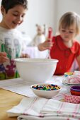 Junge und Mädchen vermischen Zutaten für Cupcakes in einer Schüssel