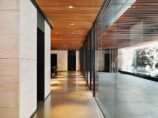 Two lobby areas separated by a wall of glass formed by sliding doors with a view of water pools