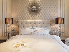 Stilisierter Sonnenspiegel über Doppelbett in klassisch elegant gestalteter Umgebung