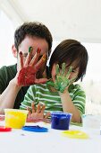 Father and son finger painting together