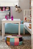 White table next to white bed and pouffe in child's bedroom