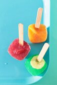 Fruit ice lollies on a blue tray