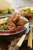 Salmon with a sesame seed crust on a bed of salad