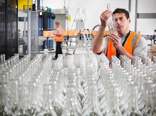 Fabrikarbeiter prüft Glasflasche