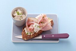 Belegtes Kürbiskernbrot mit Frischkäse, Schinken und Birnen