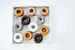 Assorted doughnuts in a wooden box (view from above)