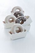 Doughnuts with sugar icing and coconut in paper cases