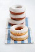 Doughnuts with sugar icing, stacked, on a striped cloth