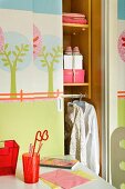 Pastel colored tree stencils on the half open sliding door of a closet in a little girl's room