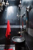 Marble washbasin and red towel with glass light fittings in Moroccan home