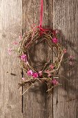 Wreath made from dried branches with pink forget me nots and carnations