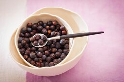 Juniper berries in a bowl and on a spoon