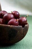 Red gooseberries in an old wooden bowl