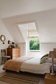 White double bedroom with sloping walls and Laura Ashley lamps