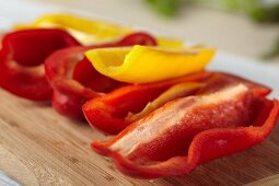 Fresh Red and Yellow Bell Peppers on a Cutting Board