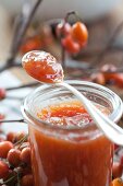 Hawthorn jam in a glass and on a spoon (close-up)