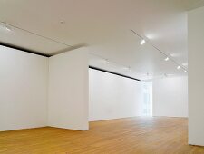 Empty gallery space lit with spotlights on a suspended ceiling and wood flooring (Photographers' Gallery, London)