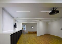 Empty gallery space with a diagonal partition wall and old wooden floor (Photographers' Gallery, London)