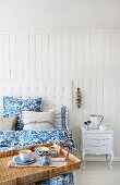 Breakfast tray on white bed with blue and white bed linen and linen scatter cushions
