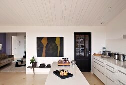 Moderne Küche mit Mittelblock in Weiß unter Holzdecke in schlichtem Wohnraum