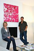 Woman and man in front of an open fire place with a modern picture on the wall