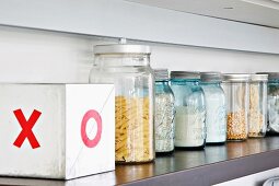 Screw top jars with dry goods on a shelf