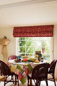 Breakfast table with patchwork tablecloth made from assorted Kathryn Ireland fabrics beneath window with Kathryn Ireland Sandeep blind fabric