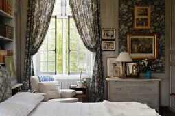 Bed next to draped curtains at lattice window in traditional bedroom
