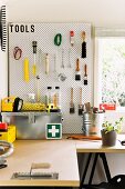 Small workshop with work table and tool wall in a garden shed