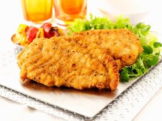 Bread chicken escalopes with a side salad