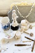 Bordüren neben Miniatur Skulptur und Vintage Abendtasche mit Perlen auf Tischtuch aus Spitze