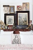 Religious pictures and statues around head of bed; scatter cushion printed with a Madonna and hearts